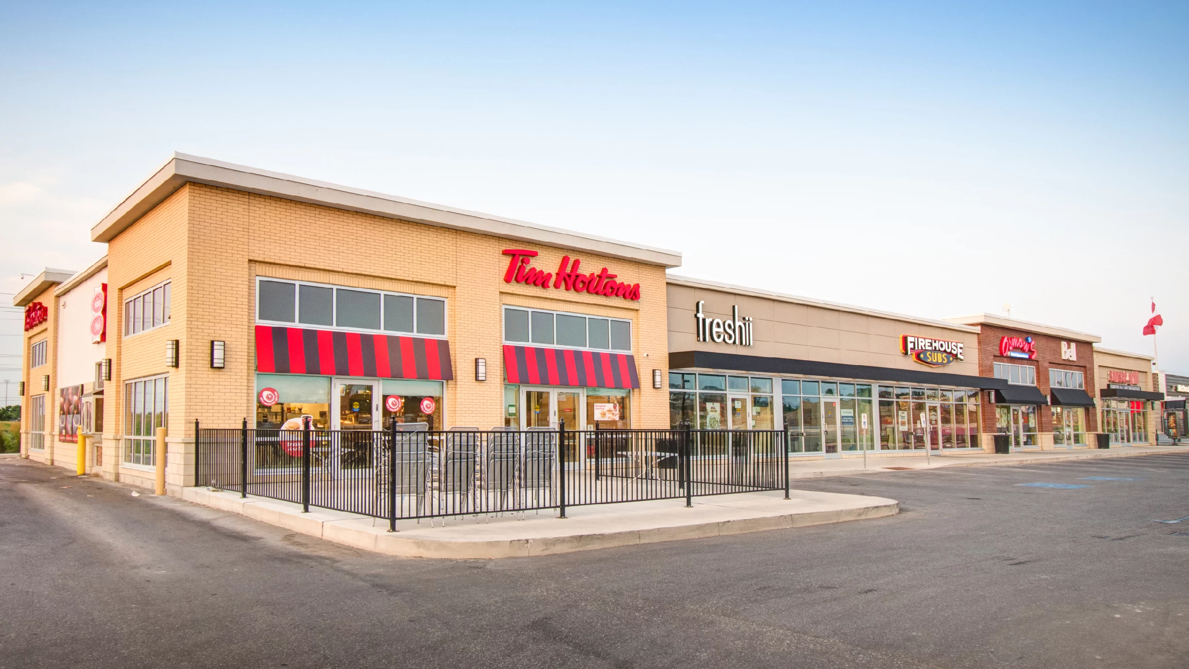 Yonge Green Lane Common, East Gwillimbury – Tim Hortons and Freshii storefronts in a retail row