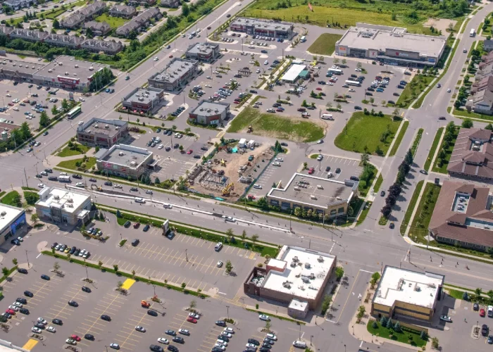 Clair Rd E & Gordon St (NEC), Guelph – aerial view of the plaza and parking lots among commercial buildings