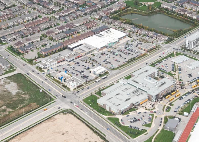 Milton Marketplace, Milton – aerial view of the plaza and parking lot beside a subdivision and pond