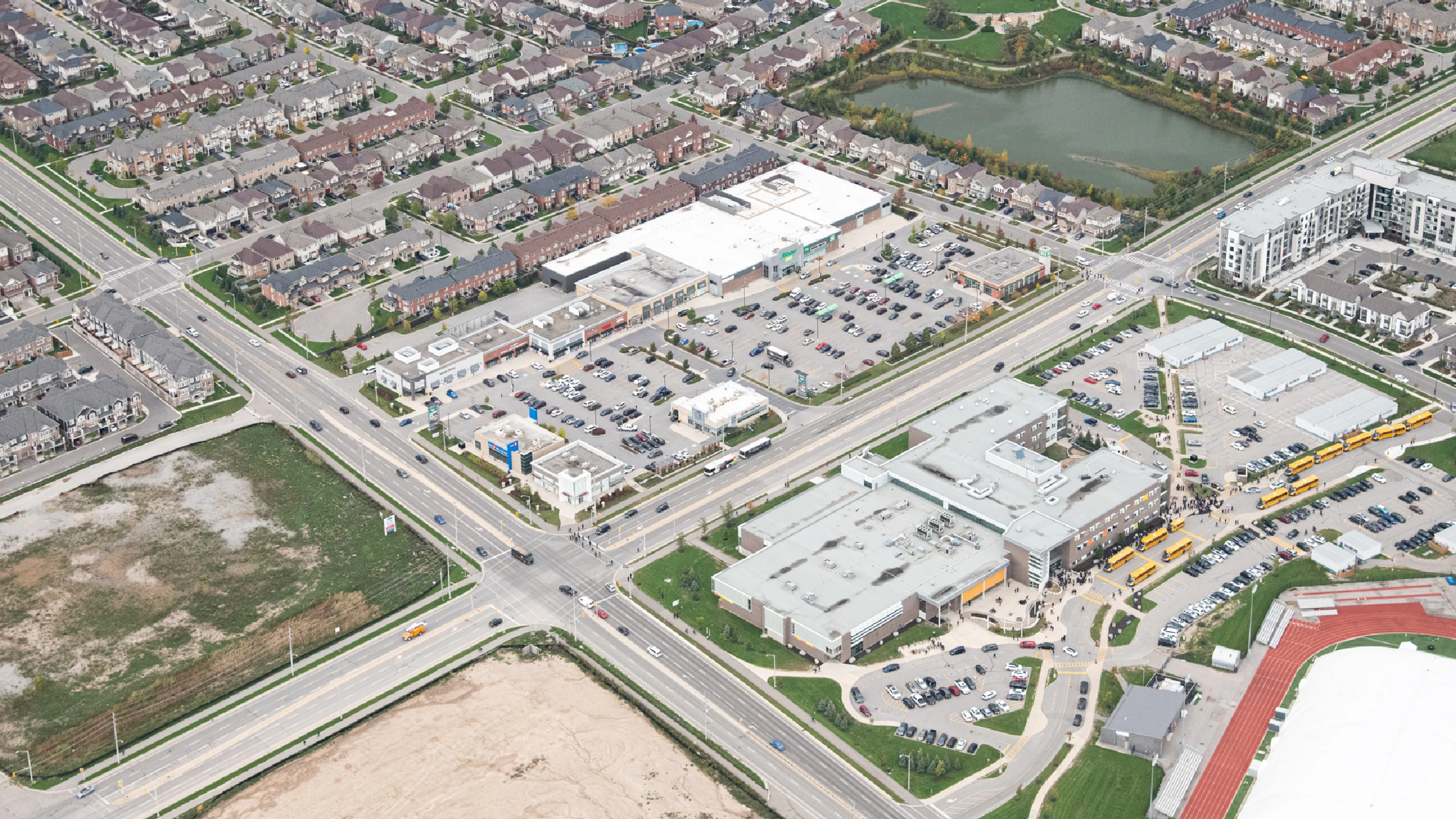 Milton Marketplace, Milton – aerial view of the plaza and parking lot beside a subdivision and pond