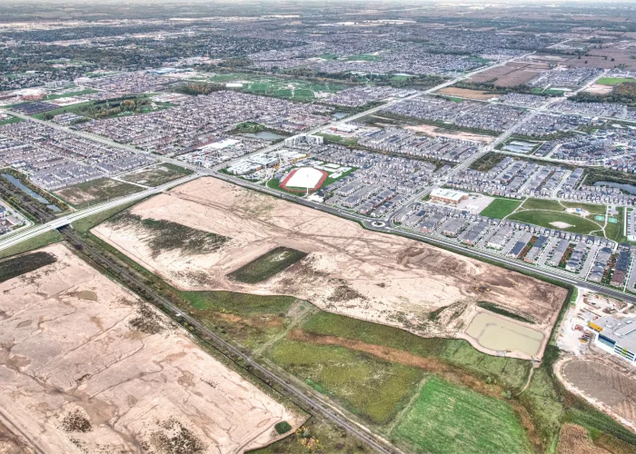 Bronte St S & Louis St. Laurent Ave (SWC), Milton – aerial view of the graded site beside a subdivision and road