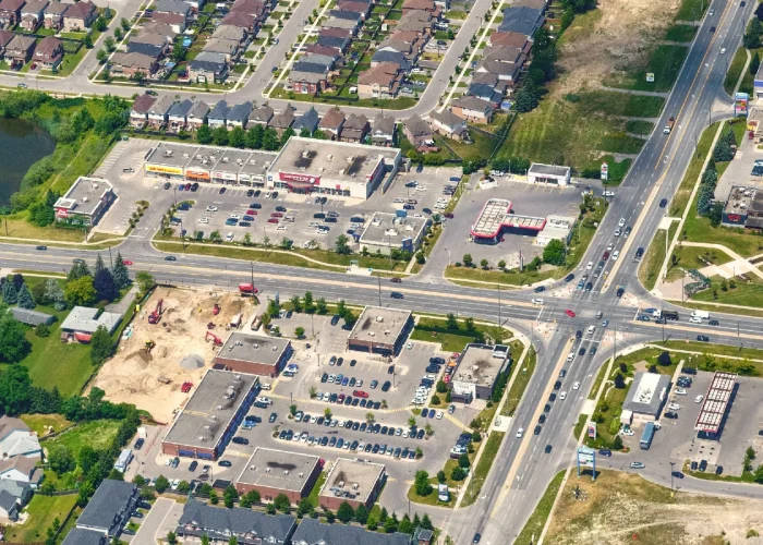 Taunton Hills, Oshawa – aerial view of the plaza and intersection beside houses and a pond