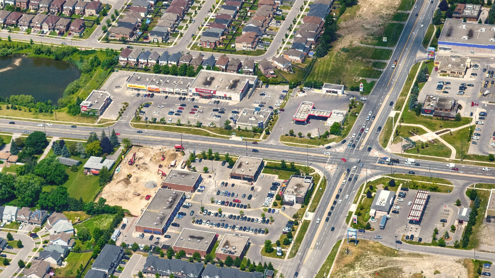 Taunton Hills, Oshawa – aerial view of the plaza and intersection beside houses and a pond