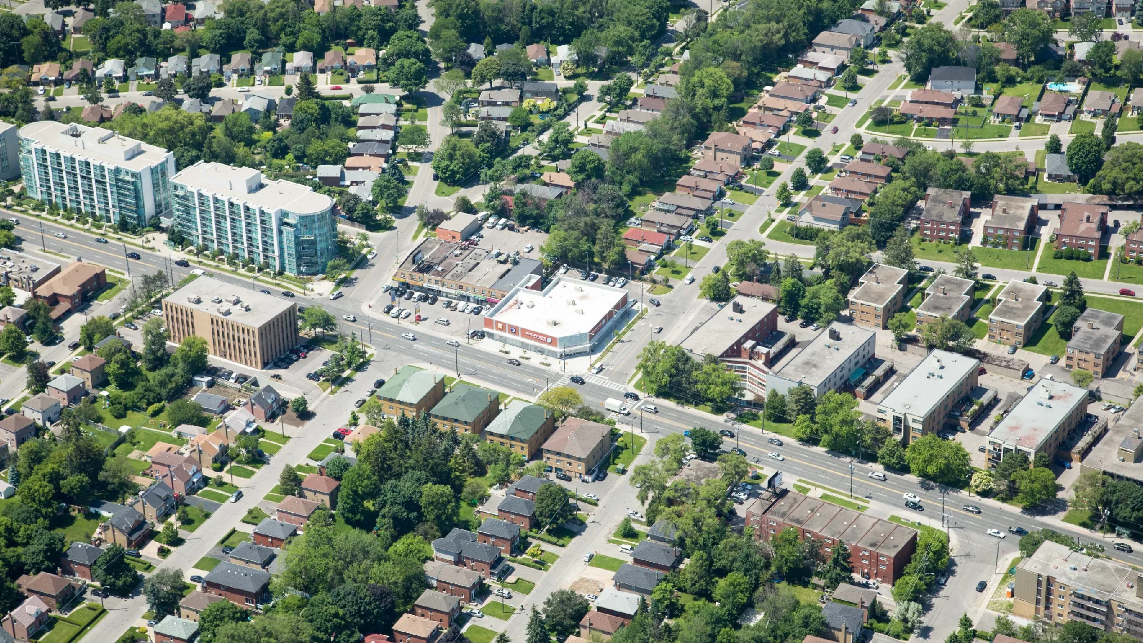 Bathurst St & Invermay Ave, Toronto – aerial view of a corner plaza among houses and a mid-rise