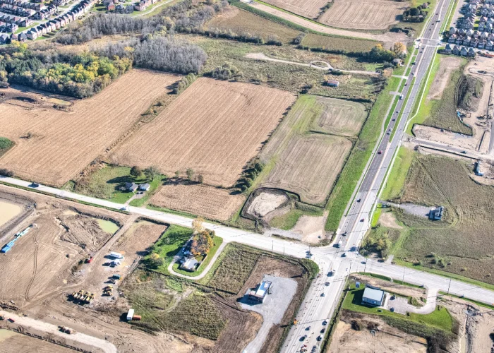 Conlin and Harmony Rd N, Oshawa – aerial view of the undeveloped site with farm fields and a road