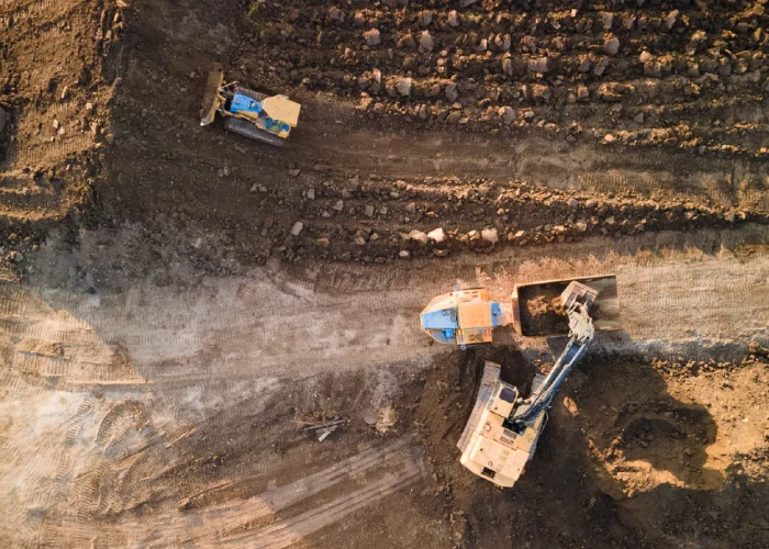 Taunton Rd W & Des Newman Blvd, Whitby – overhead view of excavators and a dump truck grading the site