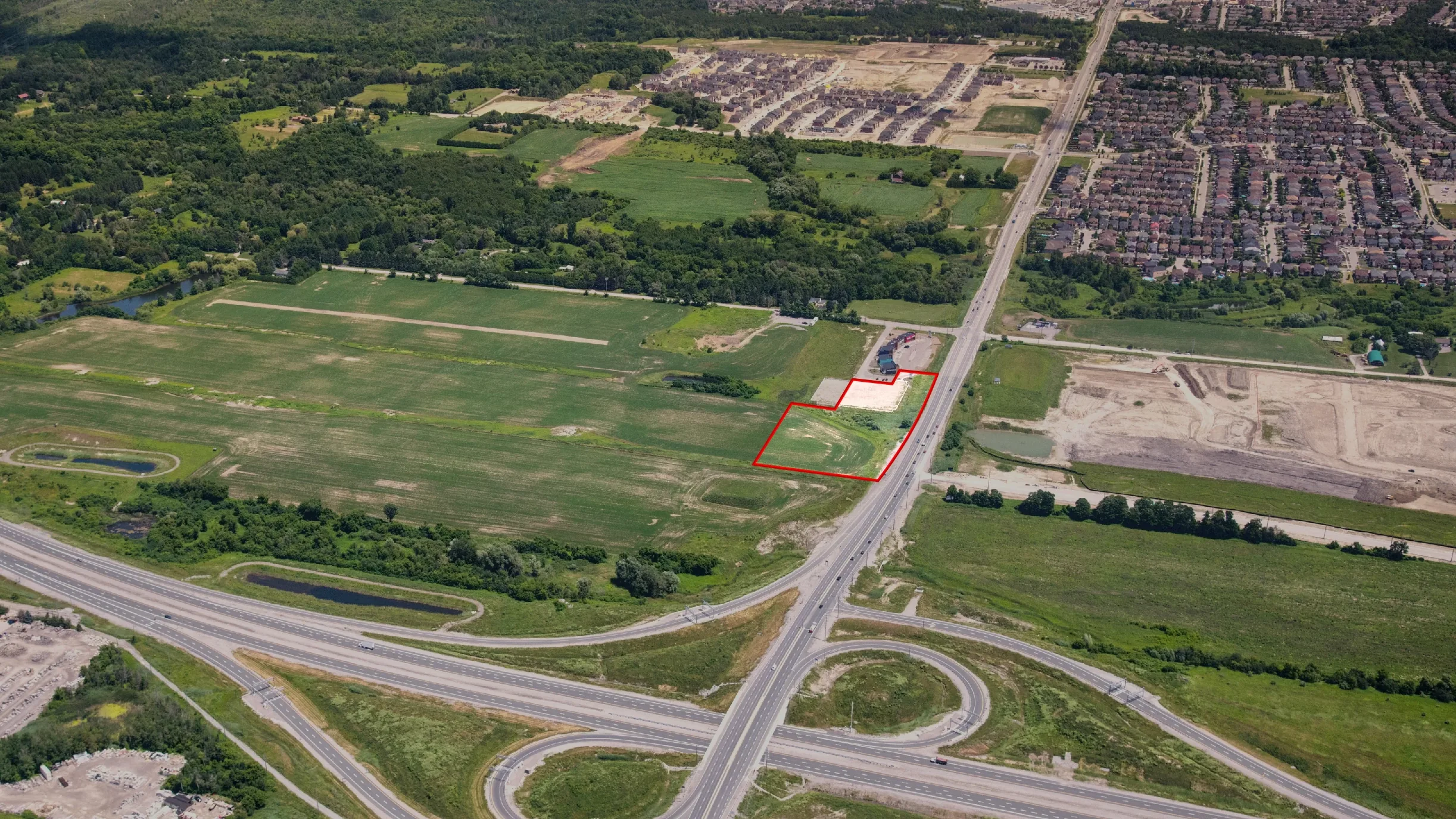 Taunton Rd W & Des Newman Blvd, Whitby – aerial view of the undeveloped site outlined in red beside a highway