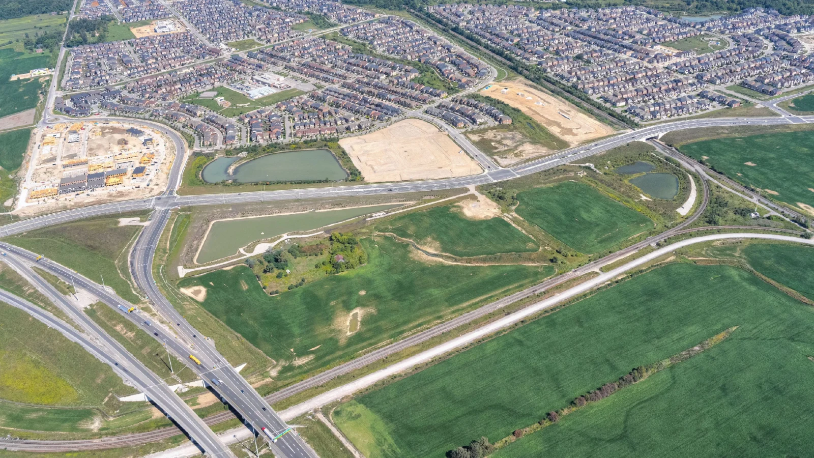 New Kleinburg Marketplace, Kleinburg – aerial view of the undeveloped site with ponds beside a highway