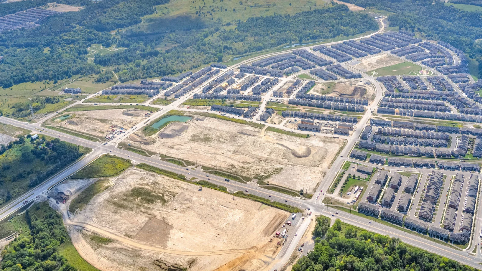 Taunton Rd & Burkholder Dr, Seaton – aerial view of the graded site beside a subdivision