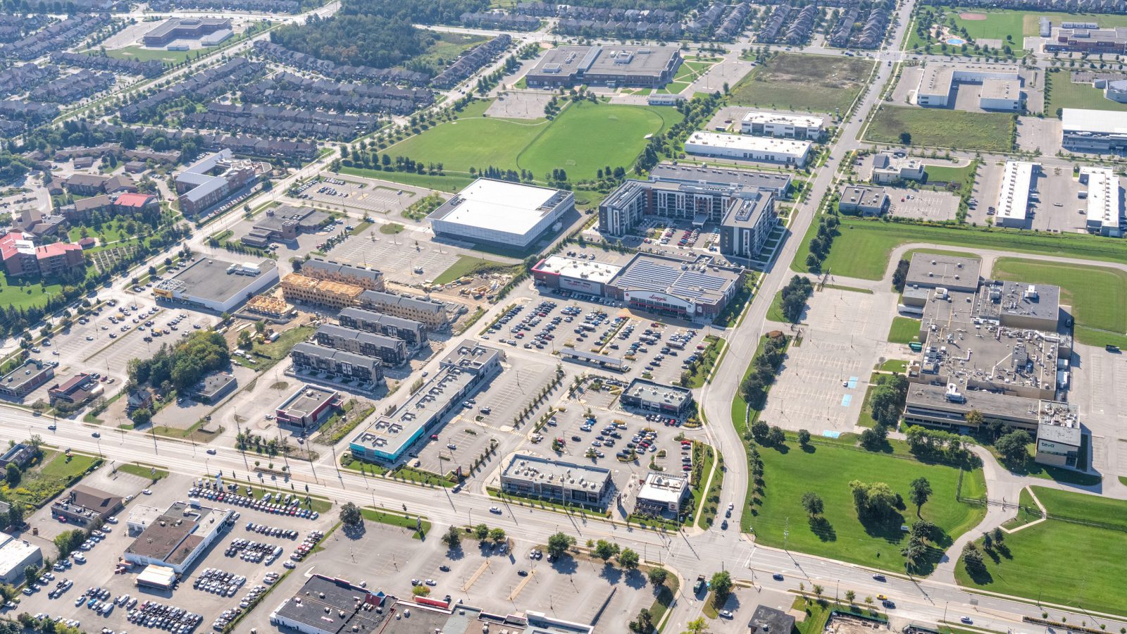 Fieldgate Commercial – aerial view of a suburban commercial district and nearby homes