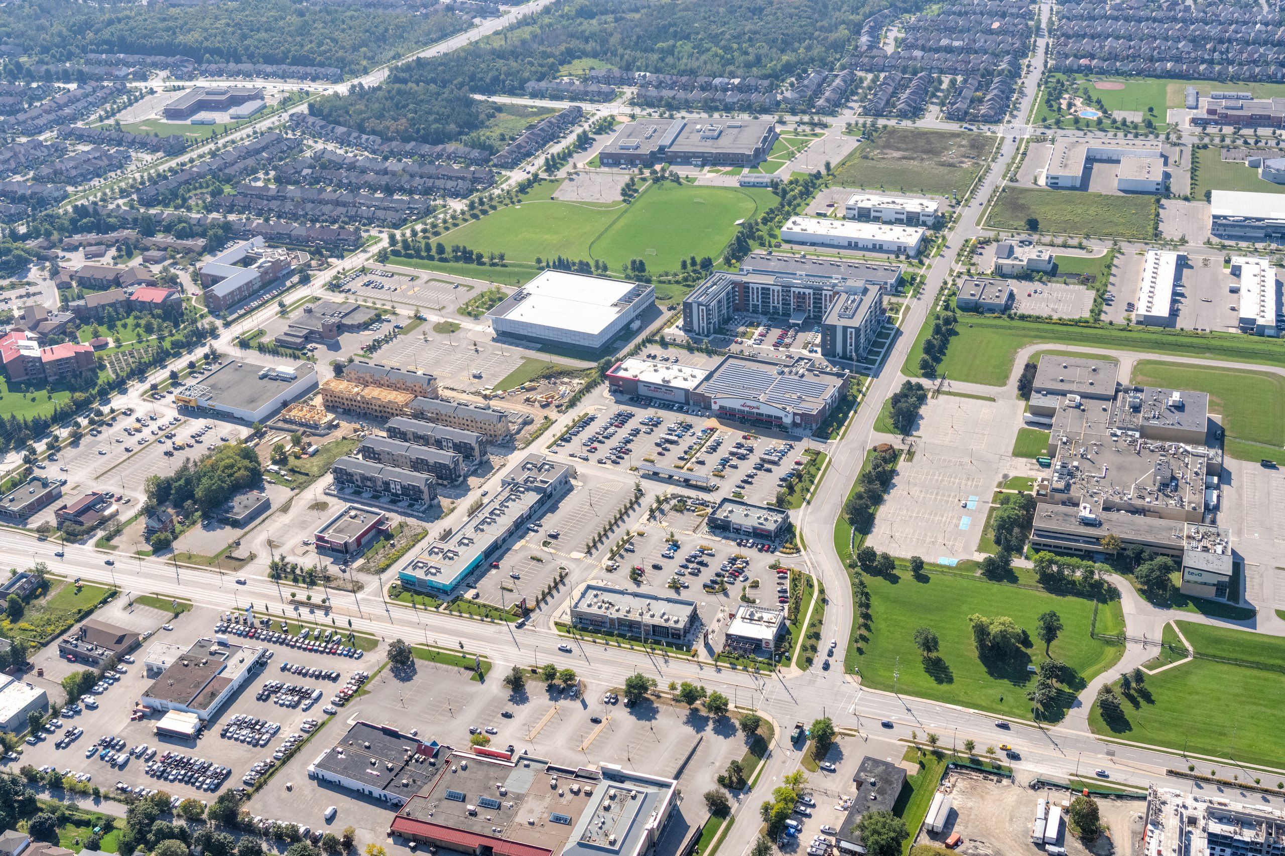 Fieldgate Commercial – aerial view of a suburban commercial district and nearby homes