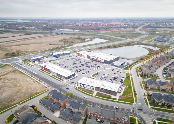 New Kleinburg Marketplace, Kleinburg – aerial view of the plaza, parking lot and pond beside a subdivision