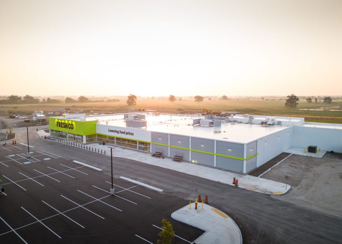 Mazmik Marketplace, Milton – aerial view of the FreshCo store and parking lot at sunrise