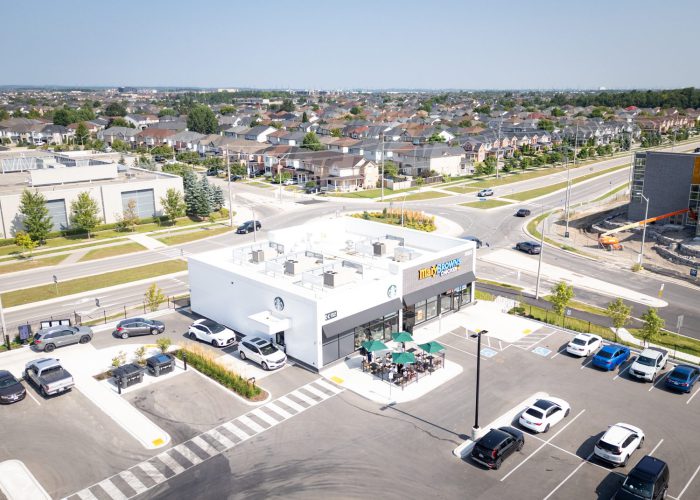 Mazmik Marketplace, Milton – elevated view of a pad building with patio and parking beside houses