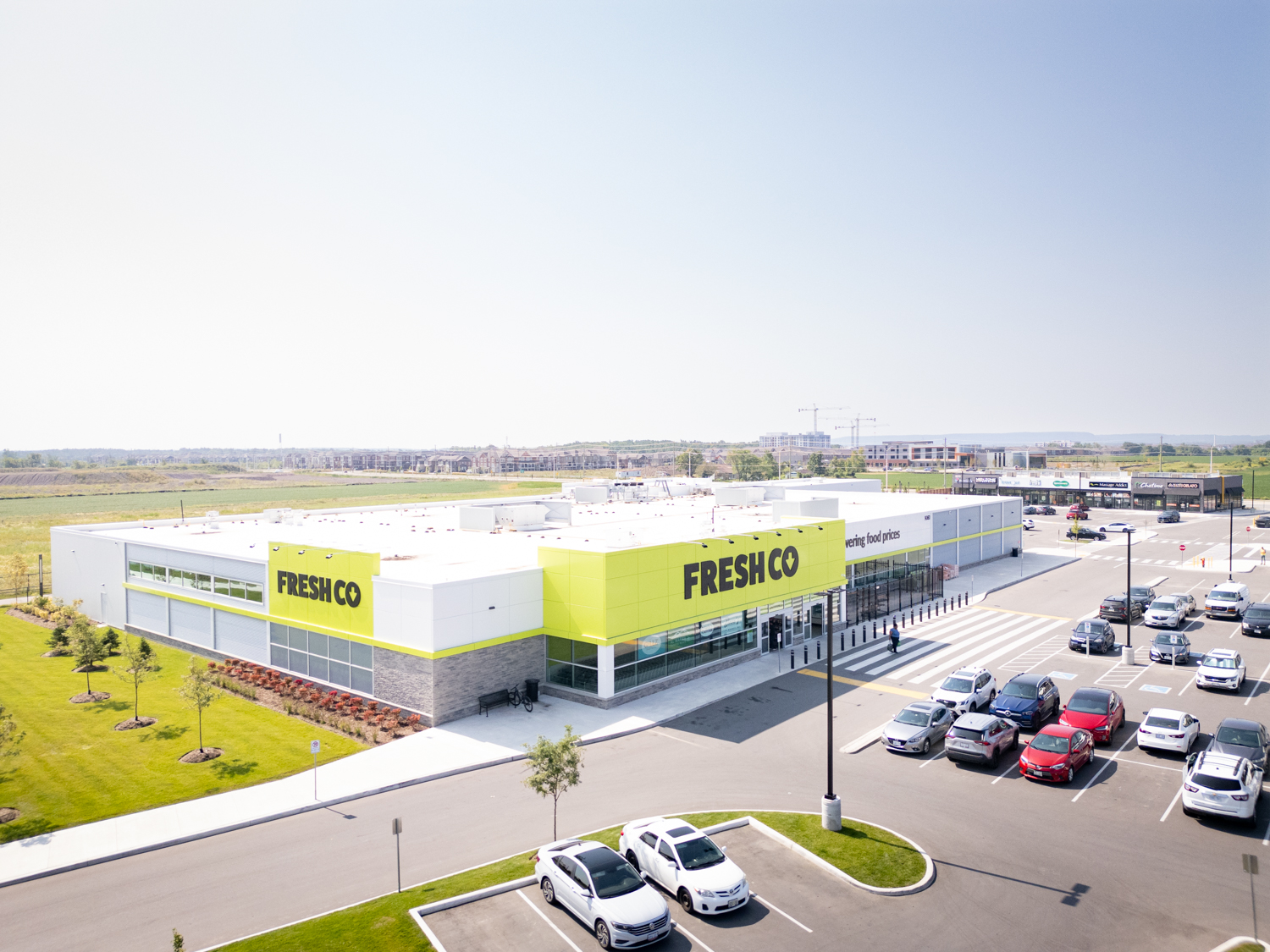 Mazmik Marketplace, Milton – aerial view of the FreshCo storefront and parking lot