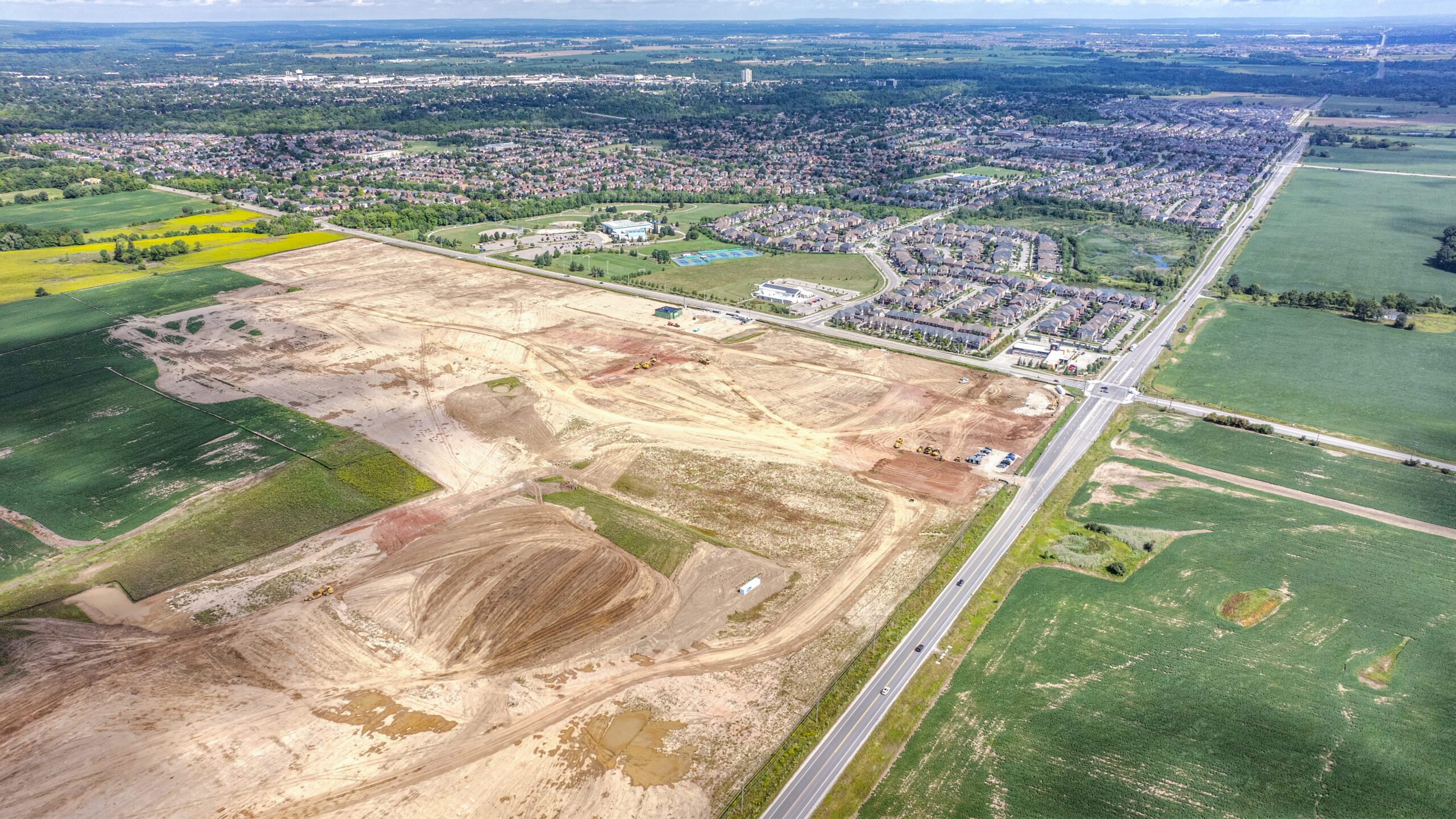 10 Side Road & 8th Line, Georgetown – aerial view of the graded site beside farmland and a road