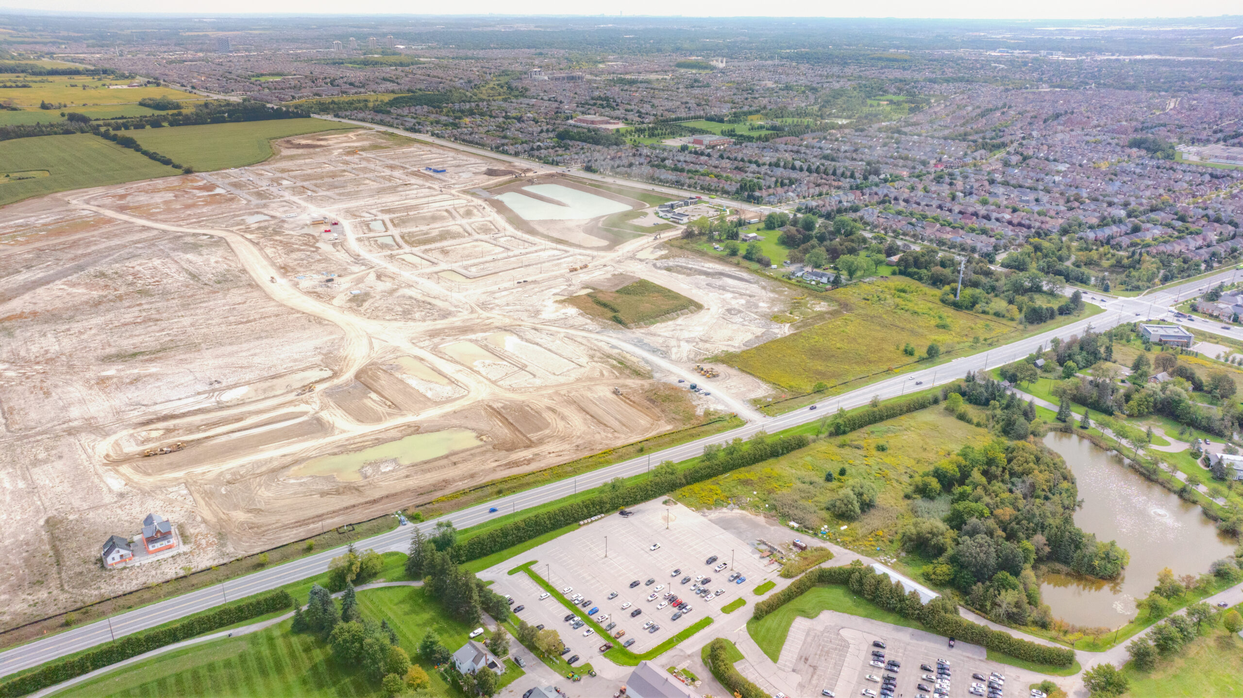 Major Mackenzie Dr E & Kennedy Rd, Markham – aerial view of the graded site beside a residential neighbourhood